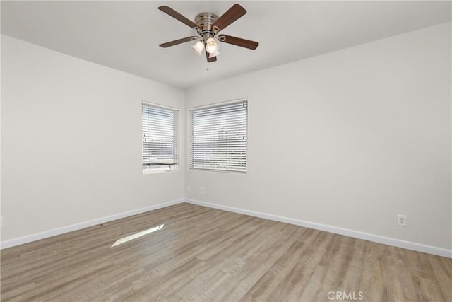 unfurnished room featuring a ceiling fan, baseboards, and light wood-style floors