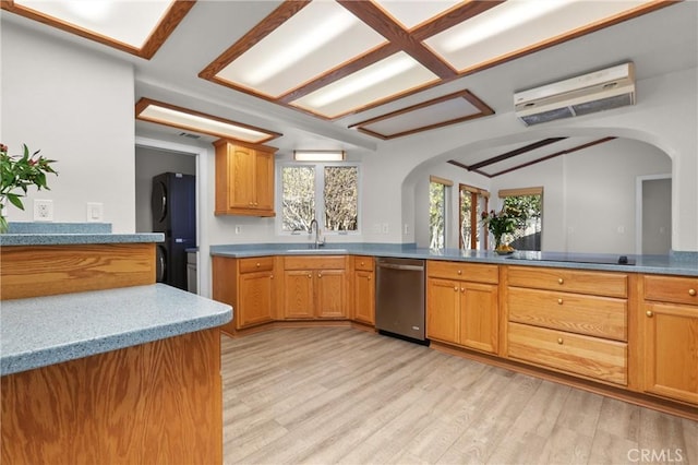 kitchen featuring light wood finished floors, black electric stovetop, stainless steel dishwasher, and arched walkways