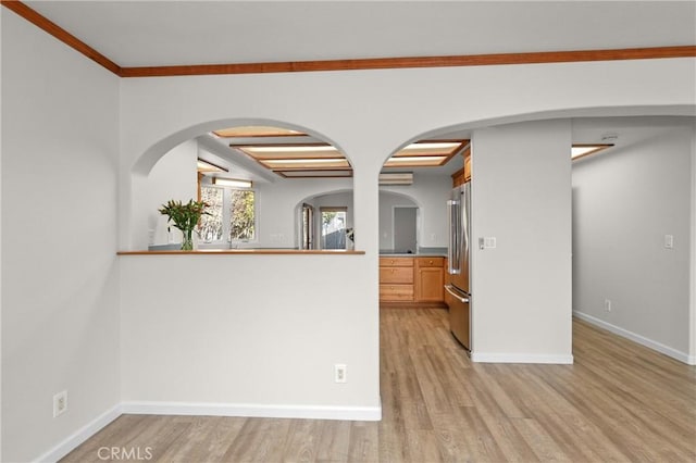 interior space with ornamental molding, light wood-style flooring, beamed ceiling, arched walkways, and baseboards