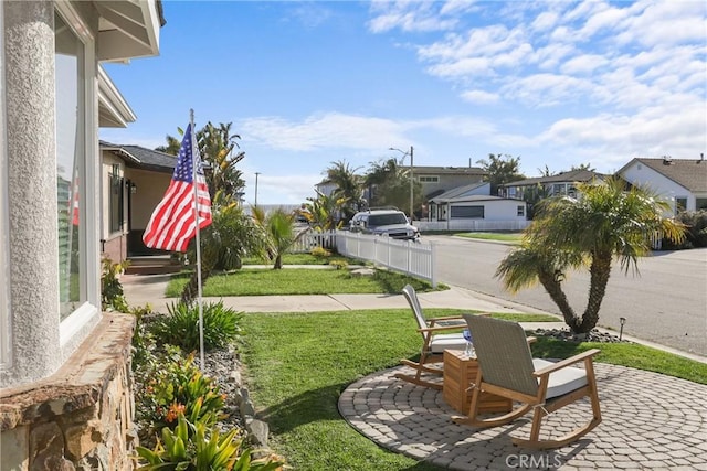 view of yard featuring fence, a patio area, and a residential view
