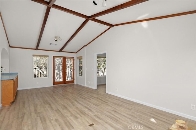 interior space featuring french doors, light wood-type flooring, baseboards, and vaulted ceiling with beams