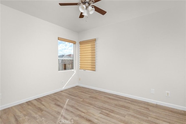 unfurnished room with wood finished floors, baseboards, and ceiling fan