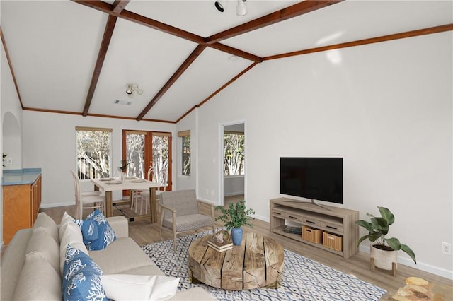 living area featuring wood finished floors, visible vents, baseboards, and lofted ceiling with beams