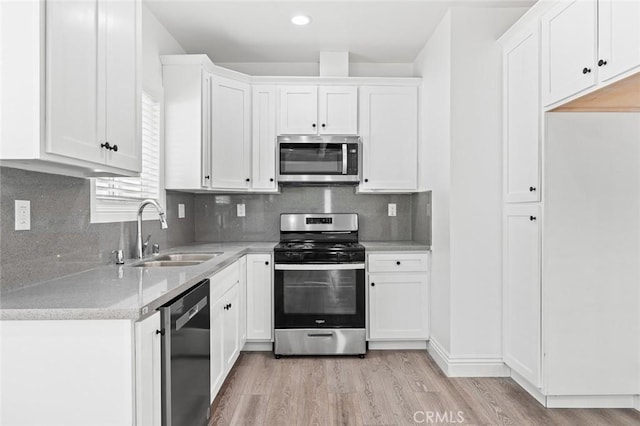 528 W 43rd St, Los Angeles, CA 90037 - kitchen featuring appliances with stainless steel finishes, light wood-type flooring, white cabinets, and recessed lighting