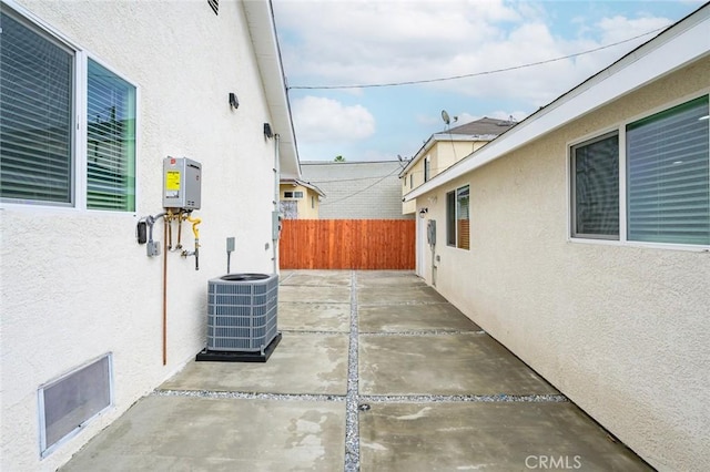 view of patio with fence and cooling unit