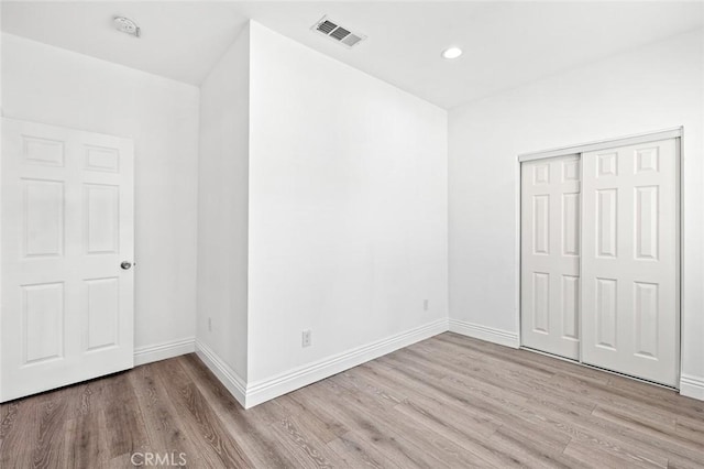 unfurnished bedroom featuring baseboards, visible vents, and wood finished floors
