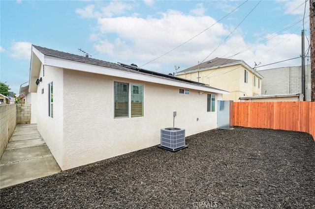 528 W 43rd St, Los Angeles, CA 90037 - back of property with stucco siding, a fenced backyard, and solar panels