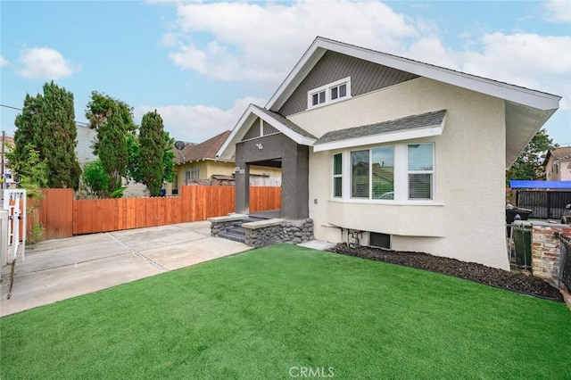 view of front of house featuring a front yard, stucco siding, and fence