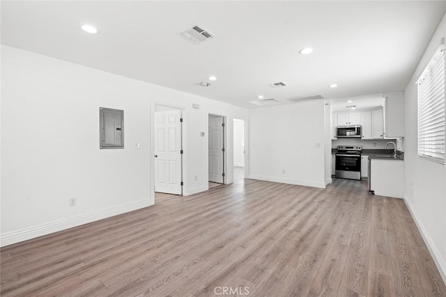 528 W 43rd St, Los Angeles, CA 90037 - unfurnished living room with electric panel, light wood-style flooring, and recessed lighting