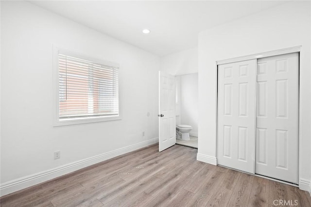 unfurnished bedroom featuring baseboards, a closet, light wood-style floors, and recessed lighting