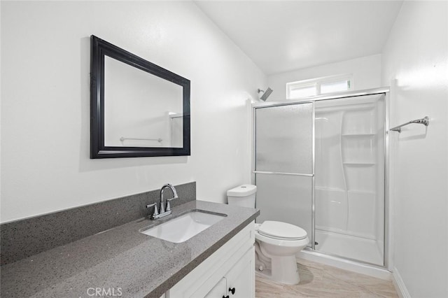 bathroom featuring vanity, toilet, and a shower stall