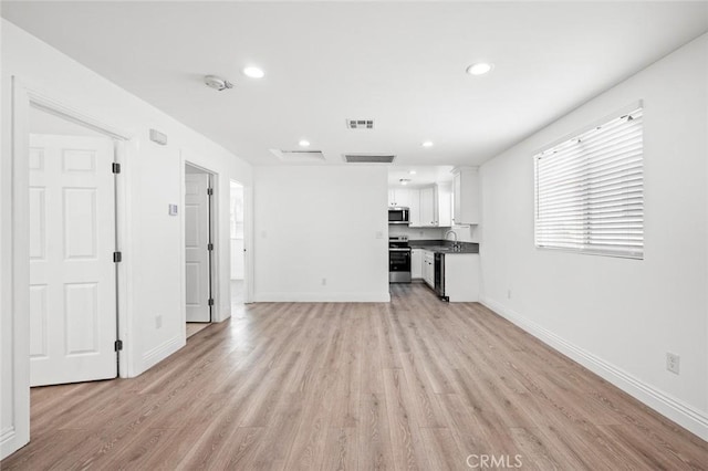 unfurnished living room with recessed lighting, visible vents, baseboards, and light wood-type flooring
