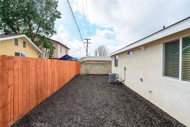 view of yard featuring central AC unit and fence