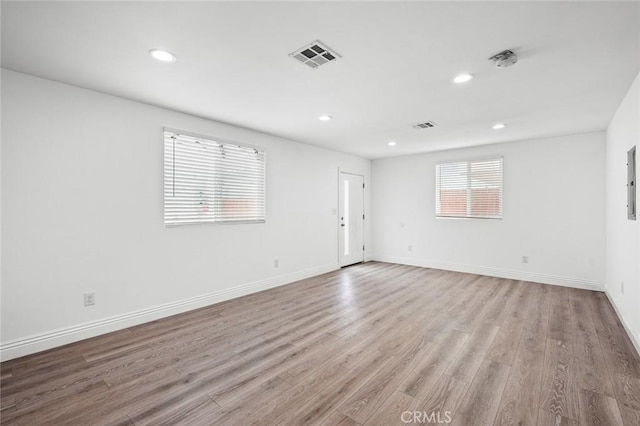 unfurnished room featuring recessed lighting, baseboards, light wood finished floors, and visible vents