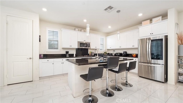 16763 Stags Leap Ln, Fontana, CA 92336 - kitchen featuring appliances with stainless steel finishes, dark countertops, white cabinetry, a kitchen island with sink, and recessed lighting