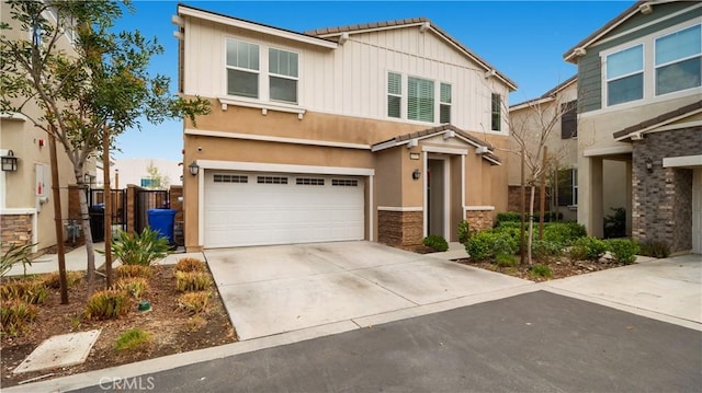16763 Stags Leap Ln, Fontana, CA 92336 - view of front of property featuring an attached garage, stone siding, concrete driveway, board and batten siding, and stucco siding
