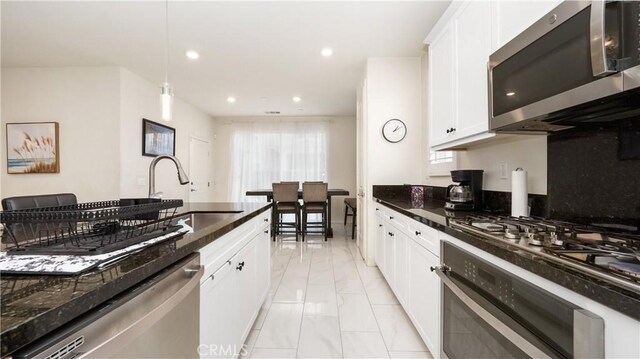 16763 Stags Leap Ln, Fontana, CA 92336 - kitchen featuring stainless steel appliances, light marble finish floors, white cabinetry, decorative light fixtures, and recessed lighting