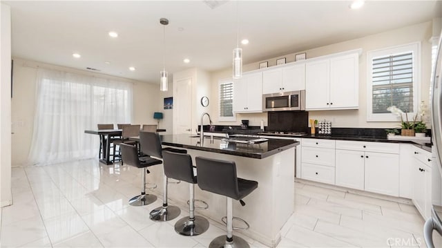 16763 Stags Leap Ln, Fontana, CA 92336 - kitchen featuring appliances with stainless steel finishes, healthy amount of natural light, white cabinets, recessed lighting, and light marble finish flooring
