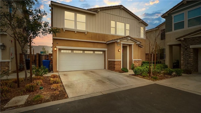 16763 Stags Leap Ln, Fontana, CA 92336 - view of front of property with a garage, stone siding, driveway, and stucco siding