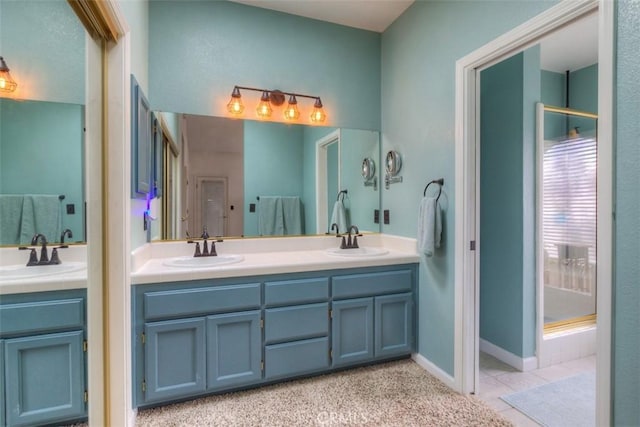full bath with a stall shower, double vanity, and a sink