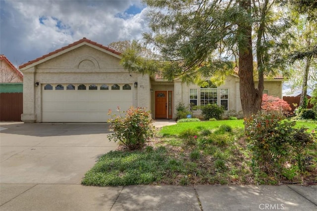 view of front of property featuring concrete driveway, fence, a garage, and stucco siding