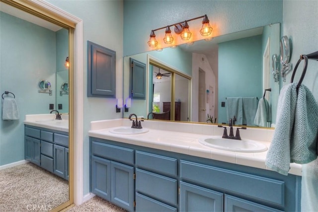 bathroom featuring a ceiling fan, a sink, and double vanity