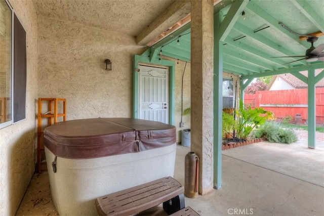 view of patio / terrace with fence and a hot tub
