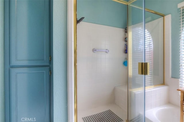 bathroom with a shower stall and a garden tub