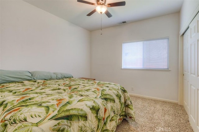 bedroom with ceiling fan, carpet, a closet, visible vents, and baseboards