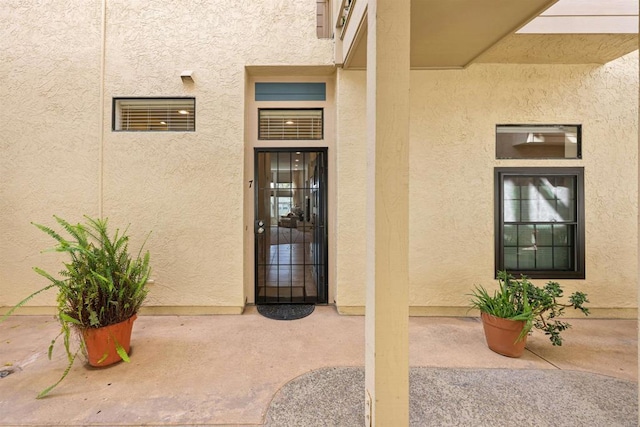 doorway to property with stucco siding and a patio area
