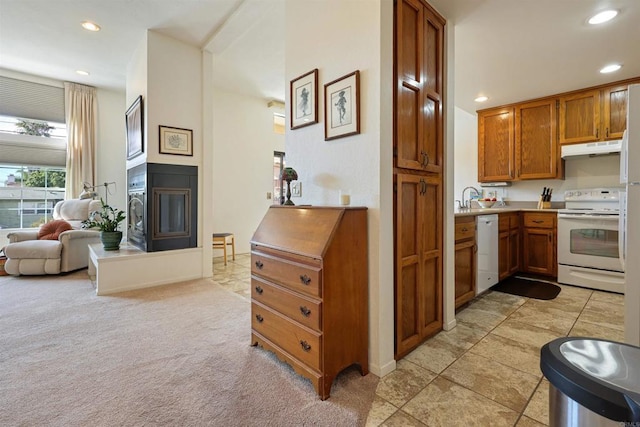 kitchen with a sink, open floor plan, brown cabinetry, under cabinet range hood, and white appliances