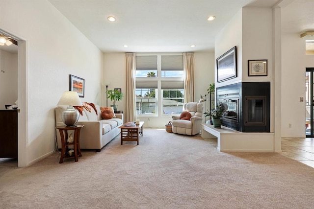 living area with baseboards, recessed lighting, carpet, and a glass covered fireplace