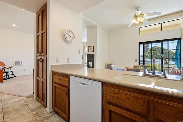 kitchen with light countertops, a sink, visible vents, dishwasher, and brown cabinets