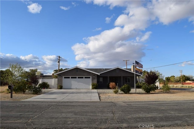 ranch-style home with fence, an attached garage, and concrete driveway