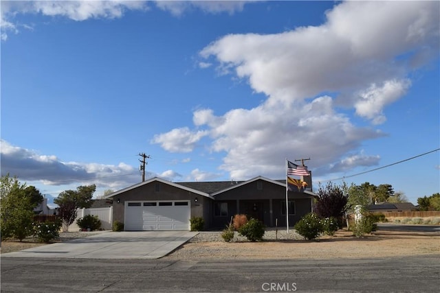 view of front of house with fence, a garage, and concrete driveway