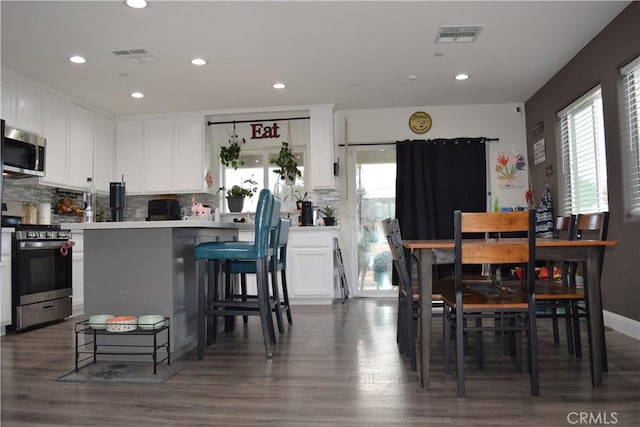 kitchen featuring white cabinets, plenty of natural light, stainless steel appliances, and visible vents