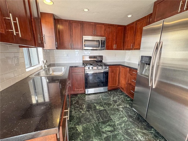 kitchen featuring a sink, marble finish floor, stainless steel appliances, recessed lighting, and decorative backsplash