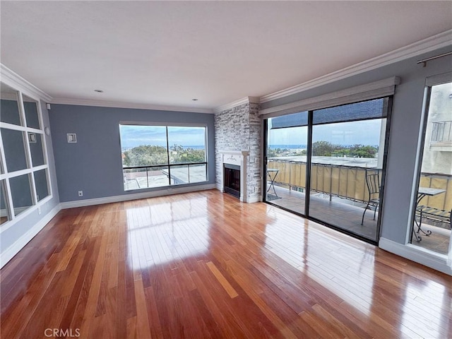 unfurnished living room featuring wood-type flooring, crown molding, and a healthy amount of sunlight
