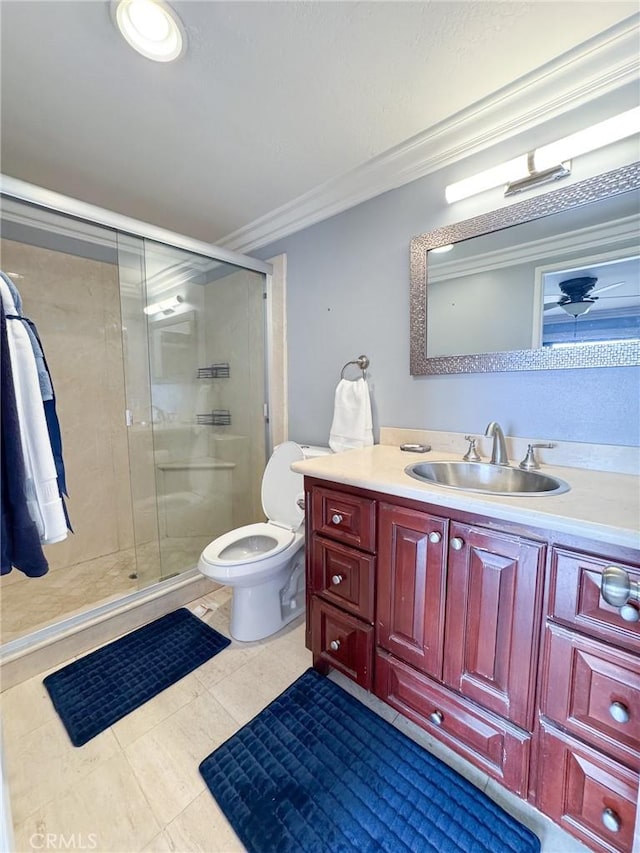 bathroom with crown molding, toilet, a shower stall, and vanity