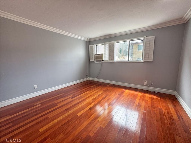 unfurnished room featuring baseboards, ornamental molding, and wood-type flooring