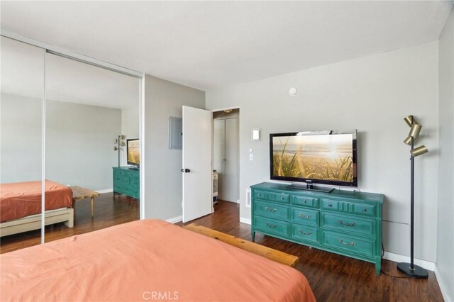 bedroom featuring dark wood finished floors, baseboards, and a closet