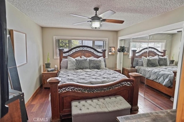 bedroom with wood finished floors, a textured ceiling, baseboards, and ceiling fan