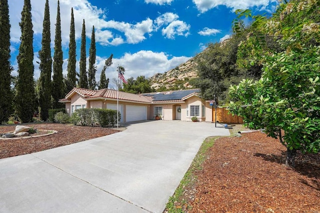 25318 Kerri Ln, Ramona, CA 92065 - ranch-style house featuring driveway, a tiled roof, roof mounted solar panels, a garage, and stucco siding