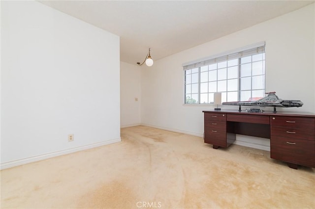 unfurnished office with baseboards and light carpet