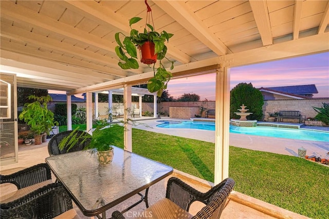 pool at dusk featuring a lawn, a fenced in pool, a fenced backyard, and a patio