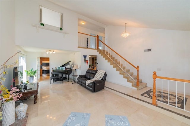 interior space featuring stairway, a chandelier, tile patterned floors, a towering ceiling, and visible vents