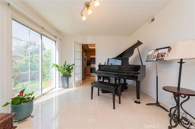 sitting room with light tile patterned floors, baseboards, and visible vents