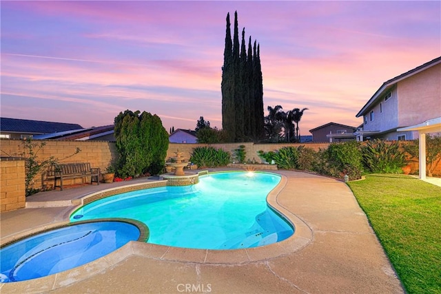 view of pool with a fenced backyard, a pool with connected hot tub, and a yard