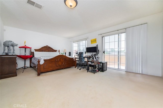 bedroom featuring carpet floors, a textured ceiling, access to outside, and visible vents