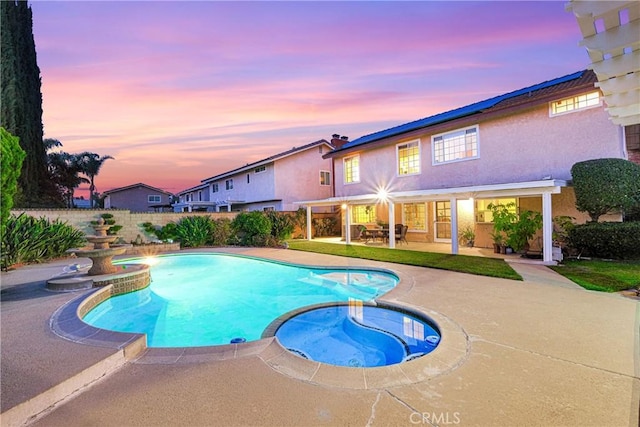 view of pool with a pool with connected hot tub, fence, and a patio area